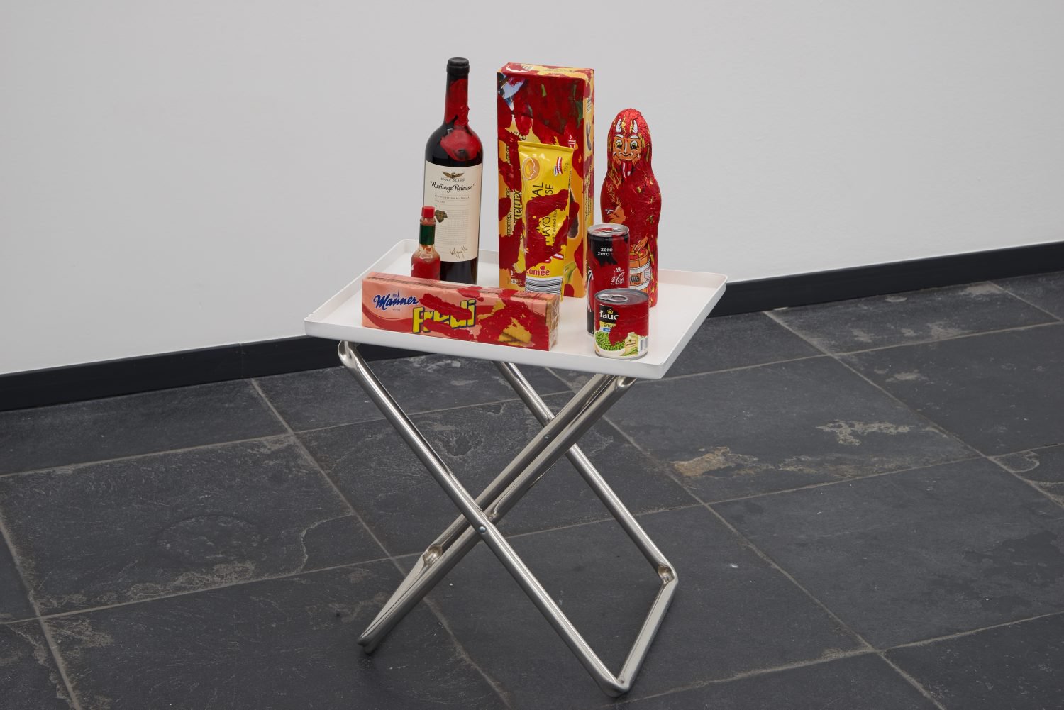 Anna-Sophie BergerComplicit 1Acrylic paint on &quot;heritage release&quot; red wine bottle, chocolate bananas, mayonaise, chocolate krampus, coke zero, manner fredi biskuits, tabasco, PVC, aluminium and polyester70 x 46 x 36 cm